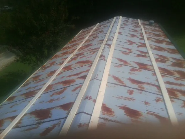Rusted metal roof panels with new wood purlins before replacement — Storm Damage Roof Repair in Arthur by Roofing Brothers